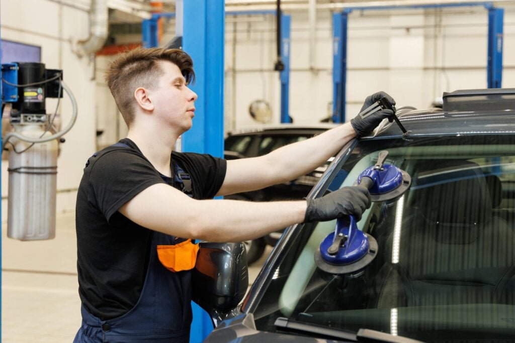 professional,mechanic,using,suction,pads,on,car,windscreen